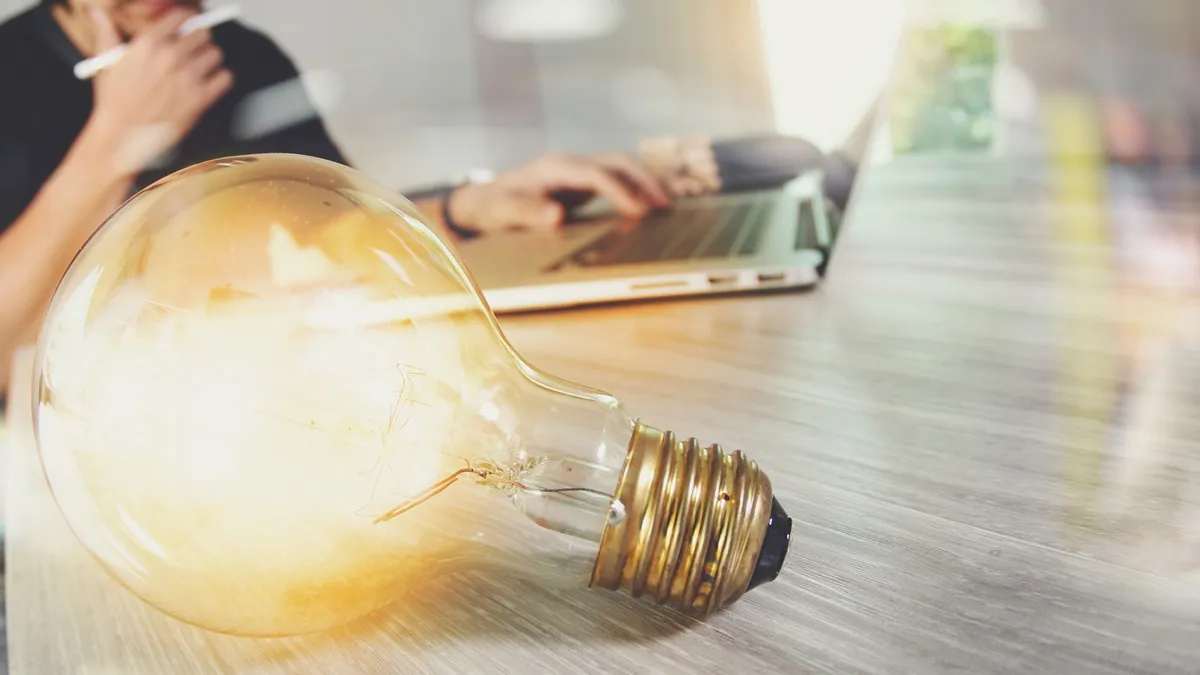 Light bulb and a laptop, an illustration of digital innovation